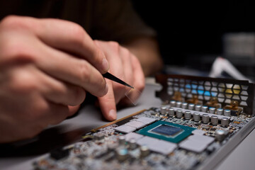Naklejka premium Hand Repairing a Graphics Card through the Application of Thermal Paste for Better Performance