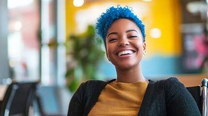 Smiling Black woman with blue hair in wheelchair at a vibrant DEIB workplace