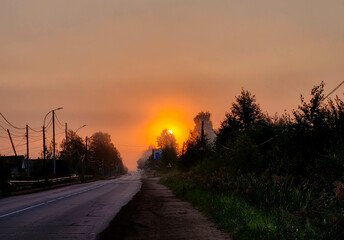 Obraz premium Early in the morning, an orange dawn. Sunrise over the countryside.