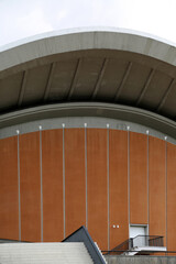 Obraz premium Unique curves and modern design of the House of World Cultures in Berlin, Germany rise against a backdrop of soft clouds, showcasing the blend of architecture and nature in the city