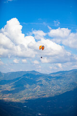 People paragliding over the beautiful mountains of the Antioquia department in Colombia. Tandem Paragliding. Extreme sport concept.