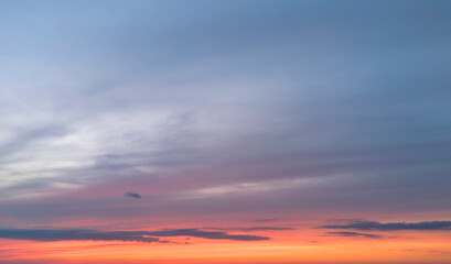 Colorful sunset sky with clouds over the horizon, perfect for backgrounds or serene nature imagery.