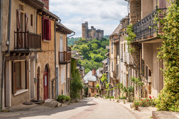 Main street in the village of Najac with fantastic view over the emerging castle in Aveyron, France