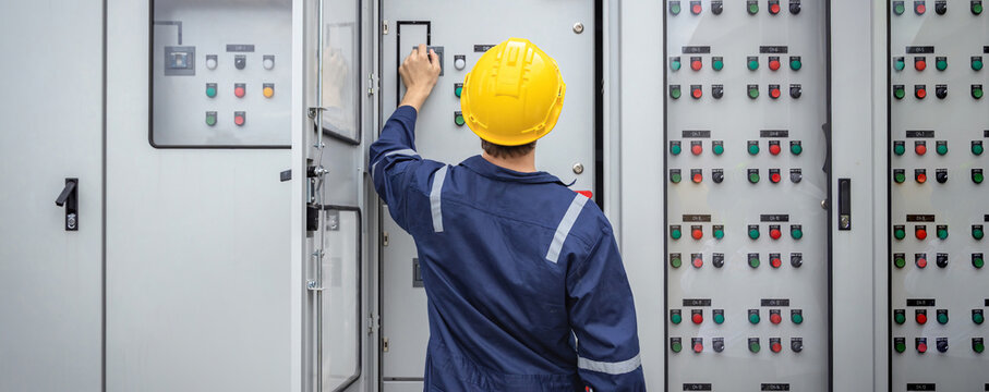 Electrical engineer working in control room. Electrical engineer man checking Power Distribution Cabinet in the control room