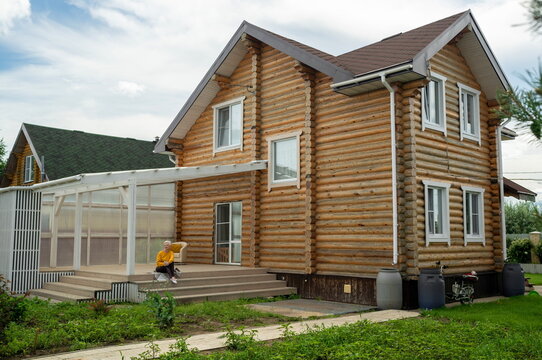 Mature woman relaxing on porch swing at log cabin home
