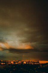 Fototapeta premium rainbow appeared against gray stormy sky over residential area of the city.