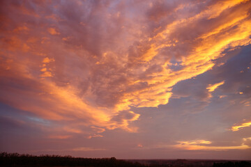 Fabulous and spectacular vivid clouds illuminated by the rays of the sun at sunset.