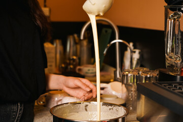 Liquid dough poured waffle iron machine to prepare Belgian waffle. Cooking process. Food preparation. Making Belgian waffles. Female hand pours dough into waffle maker in kitchen at home. Breakfast.