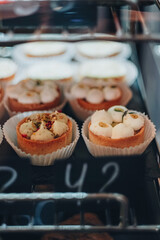 Desert with price tag. Display case with a variety of cakes, cupcakes and deserts. The tarts with...