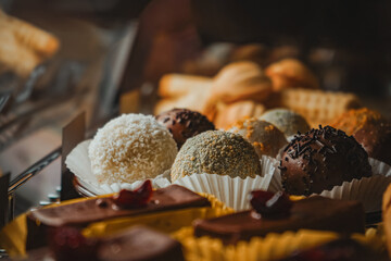 Delightful cafe sells various kinds of cakes in glass display cases. Blackforest, cheesecake, nuts with condensed milk and dessert in the form of round balls of different colors.
