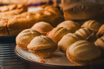 A display case of a bakery or coffeeshop. Various types of mini desserts in a display case. Modern bakery or patisserie. A dessert of nuts with condensed milk with a pie nearby.