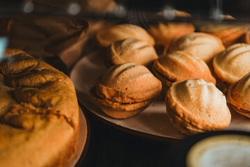 A dessert of nuts with condensed milk with a pie nearby. A display case of a bakery or coffeeshop....