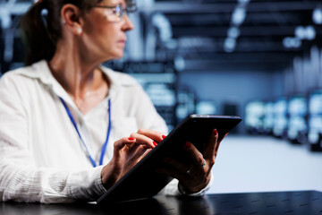 Trained serviceman using tablet to assess server security blips arising due to unsecured network...