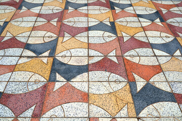 Puerto de Mogan, Gran Canaria, Spain. Colorful mosaic tiles with the image of fish on the sidewalk in the town