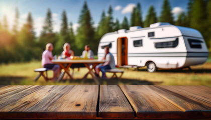 High angle view of a diverse group of young people, family, while enjoying an outdoor picnic at the campsite with a trailer truck, empty table for text space and display products