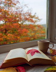Open Book with Coffee in Window Seat During Fall Season