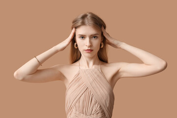 Fototapeta premium Beautiful young woman with stylish jewelry on brown background