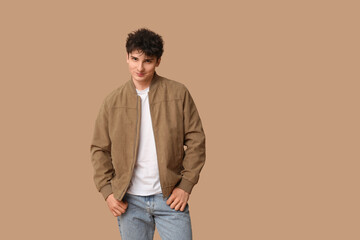 Handsome young man in stylish clothes on brown background