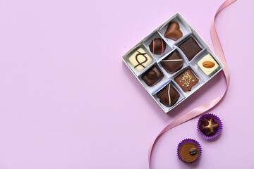 Box with delicious candies on purple background