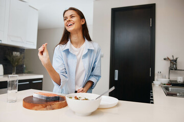 Woman standing in front of kitchen table with bowl of food on it in cozy domestic setting