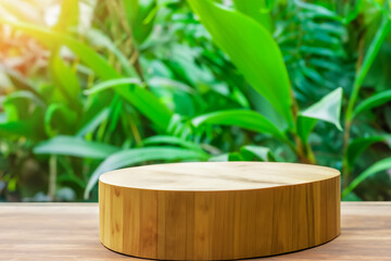 Wooden product display on table with blurred green foliage background.