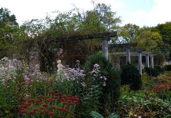Grecian Statue Replica, Trellis, and Flowers in Beautiful Garden