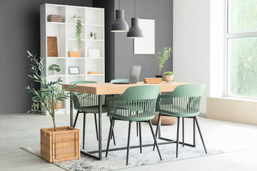 Interior of dining room with table, shelf unit and plants