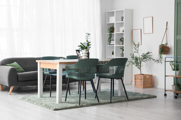 Table with chairs and sofa in interior of light dining room