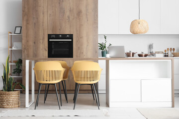 Wooden table and chairs in interior of modern dining room