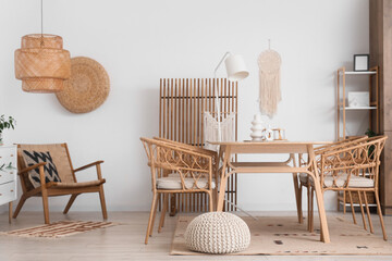Stylish interior of dining room with wooden furniture near white wall