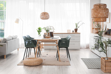 Pouf, chairs and table near window in interior of stylish dining room