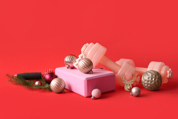 Composition with sports equipment and beautiful Christmas decorations on red background
