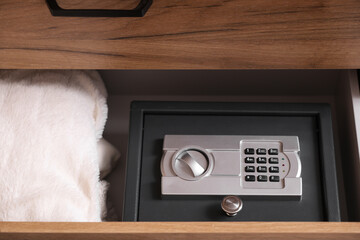 Open drawer with safe and plaid in room, closeup
