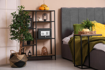 Interior of bedroom with modern safe on shelf