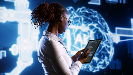 IT specialist updating AI systems, writing intricate binary code scripts on tablet, visualizing result wth AR. Licensed employee using programming to upgrade artificial intelligence simulation model