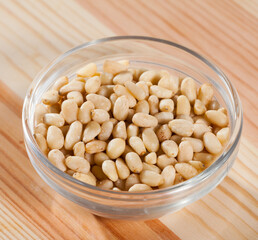 Pile of delicious pine nuts on a wooden surface