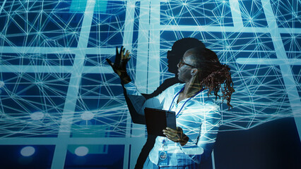 Computer scientist programming in AI server farm housing advanced equipment used for machine...