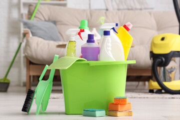 Bucket with cleaning supplies on floor in living room