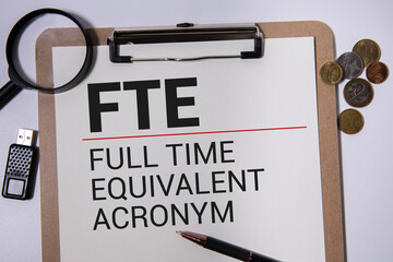 Text FTE Full Time Equivalent writing on notebook with hand holding pencil,