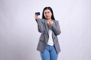 beautiful young office lady disgusted pointing and holding debit credit card wearing grey suit standing isolated on white background. for corporate, lifestyle, finance, transaction content