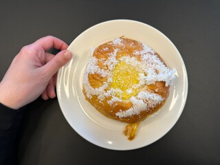 Skolebolle, Stortorget, Tromsø, Norway - nostalgic treat skolebrød white plate held with hand at...