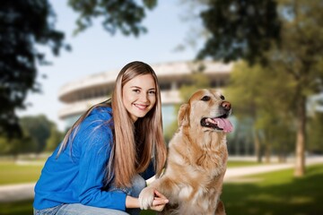 Beautiful young woman walks in autumn park wirh dog