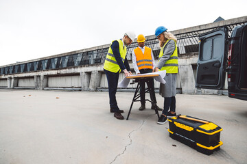 Construction industry and engineering - engineers, architects and contractors on the construction site analyzing the development of the building