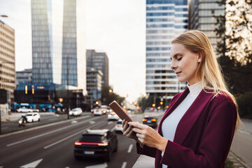 Young caucasian woman portrait on the street in dusk with digital tablet. Walking in business district.