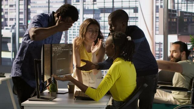 Upset IT workers in office debating, doing brainstorming, looking through lines of code on computer. Team of company employees discussing in workspace, disagreeing with each other, camera A