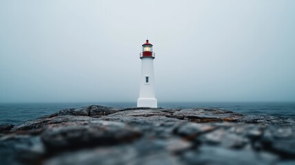 Lighthouse standing tall in the foggy ocean