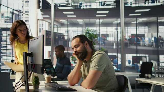 Fatigued software engineer caught asleep at desk by manager while developing artificial intelligence tech. Team leader waking up lazy worker while training predictive models, camera B