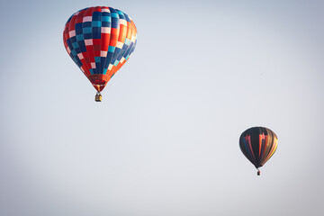 Two hot air balloons in the sky at sunrise