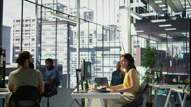 Manager discussing with employees in office, developing artificial intelligence machine learning APIs. Team leader doing brainstorming with workers, training AI predictive models, camera B