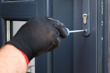 Repairman installing new door with screwdriver indoors, closeup